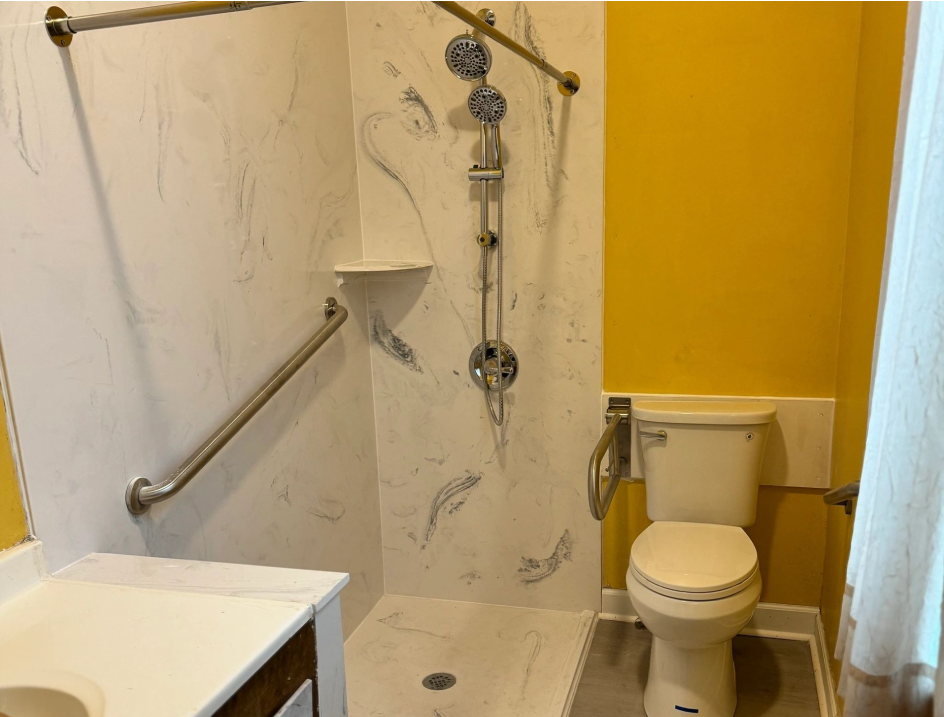 A bathroom with a toilet, shower and sink.